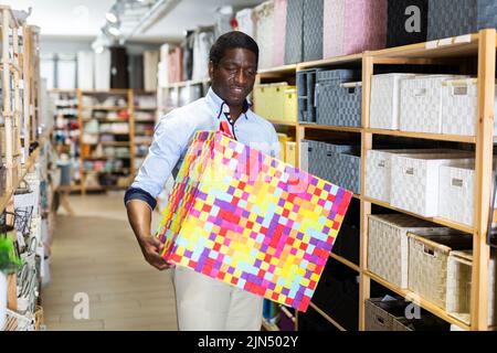 Man with plastic laundry box at store Stock Photo