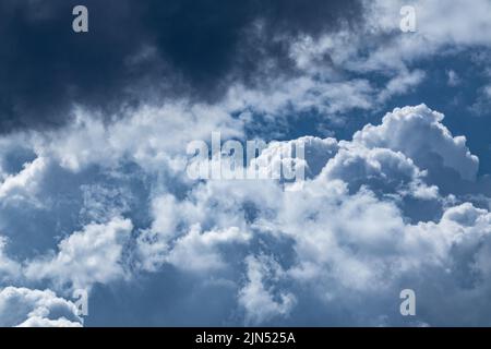 High layered white epic clouds on blue dramatic dark sky. Heavenly cloudscape background Stock Photo