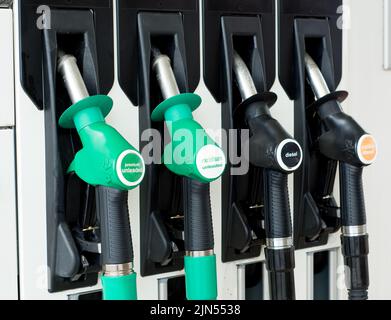 View of four petrol and diesel fuel nozzles in position on the pump dispenser at a  refueling station within the London area, UK. Stock Photo