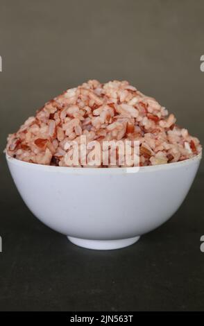 steamed rice or nasi merah served in plate isolated on black background ...