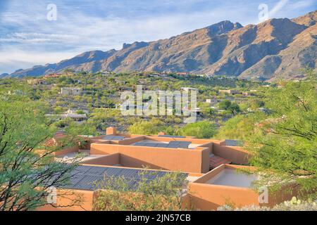 Mediterranean upper middle class houses on a sloped suburbs near the mountain range in Tucson, AZ. There is a view of solar panels on top of a roof of Stock Photo