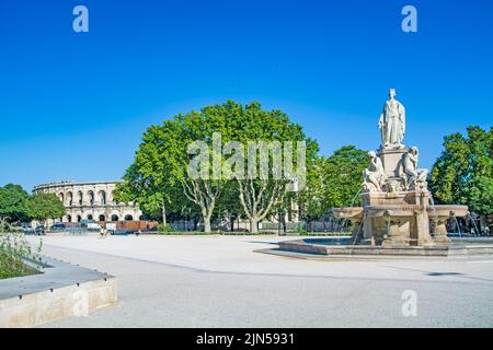 Nimes, city in Southern France, Gard, Occitanie, Pradier fountain and Arena of Nîmes, Roman amphitheatre on summer day Stock Photo