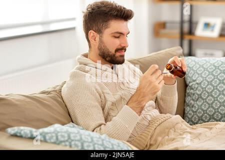 sick man pouring medication from bottle to spoon Stock Photo