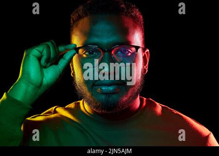 young african american man in glasses over black Stock Photo