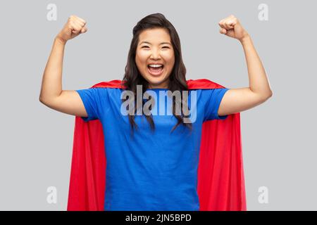 happy asian woman in red superhero cape Stock Photo