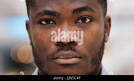 Male portrait of close-up serious african american man looking in camera confident young businessman freelancer stands indoors professional model male Stock Photo