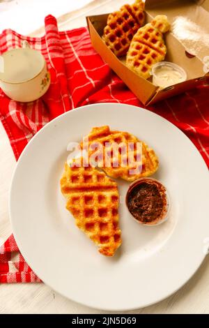 Croissant Waffle or Croffle with chocolate sauce served in box and white background Stock Photo