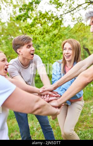 Young people celebrate success by stacking hands or doing a team motivation exercise Stock Photo