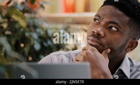 Close-up pensive confident manager freelancer working on laptop writes report thinks about solving problem startup new idea focused deep in thought Stock Photo