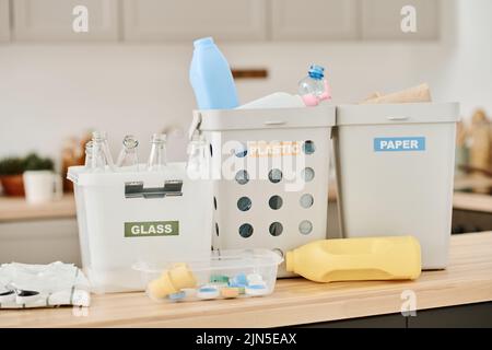 Close-up of containers for plastic, glass and paper standing on table in the kitchen Stock Photo