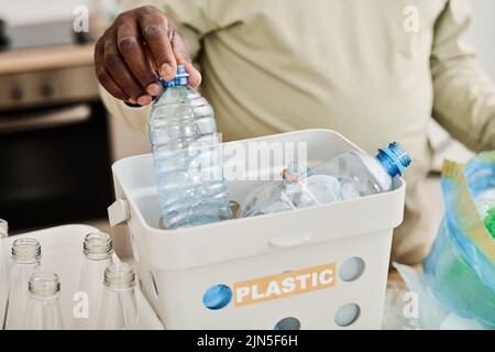Close-up of African man sorting plastic bottles in containers for recycling Stock Photo