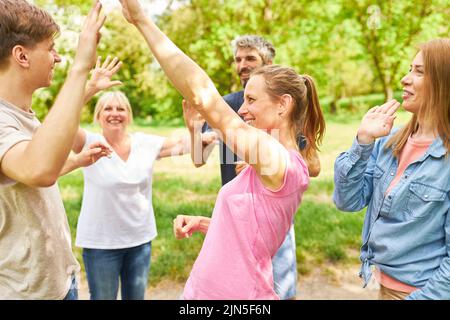 Group of young people doing exercise for motivation and cooperation in team building workshop Stock Photo