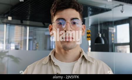 Close-up caucasian serious puzzled clever guy student in glasses looking at camera posing indoors young man with sad expression feeling upset male Stock Photo