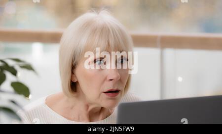 Close-up surprised excited mature woman looking at laptop screen middle-aged caucasian businesswoman user reading bad news on internet getting Stock Photo