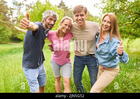Group of young people as friends showing thumbs up for optimism and community Stock Photo