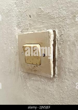 An old fashioned light switch mounted on a white wall Stock Photo