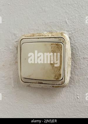 An old fashioned light switch mounted on a white wall Stock Photo