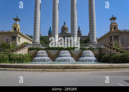 Horizontal shot of the National Palace of Catalogna in Montjuic, Barcelona, Spain with a waterfall fountain and pillars in the frontground Stock Photo