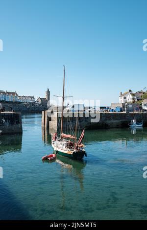 A beautiful ketch leaves Porthleven harbour Stock Photo