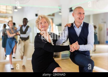 Mature woman dancing swing with young man Stock Photo