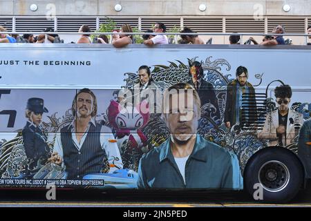 People ride on a sightseeing bus covered with an advertisement for the Brad Pitt movie 'Bullet Train' in New York. Stock Photo