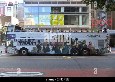 People ride on a sightseeing bus covered with an advertisement for the Brad Pitt movie 'Bullet Train' in New York. Stock Photo