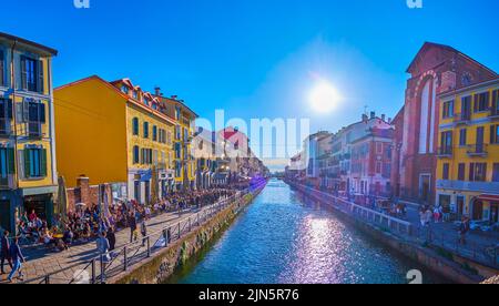 MILAN, ITALY - APRIL 9, 2022: The sunset over Naviglio Grande Canal with a view of old colorful houses and Santa Maria delle Grazie al Naviglio Church Stock Photo