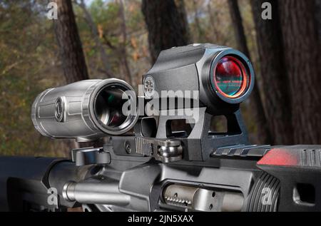 Magnifying sight swung out of the way on an AR-15 in the forest Stock Photo