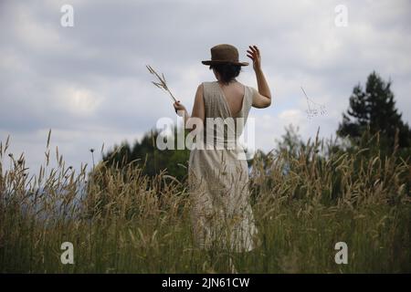 Mysterious woman in a hat walking among the spikes Stock Photo