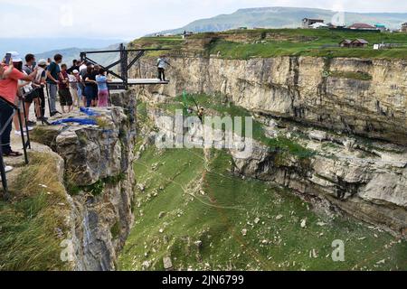 Dagestan, Russia - 21 July, 2022: Man jumps from platform above the canyon of Khunzakh and the Tobot Waterfall. Bungee in the canyon Stock Photo