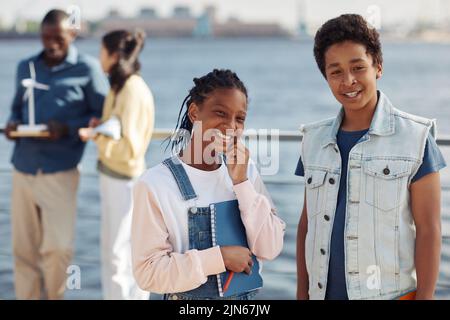 Waist up portrait of two black teenagers smiling at camera during outdoor class in sunlight, copy space Stock Photo