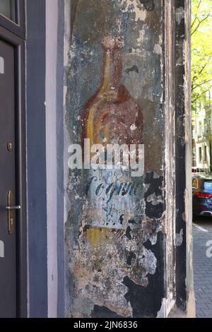 Cracow. Krakow. Poland. Bottle of cognac, an old exterior vintage wall painted ad of former restaurant. Stock Photo