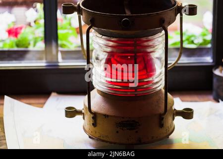 Red marine signal light stands on a windowsill, close up photo Stock Photo