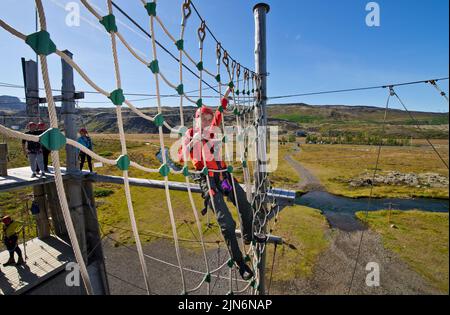 boy playing at high rope access course in Iceland Stock Photo