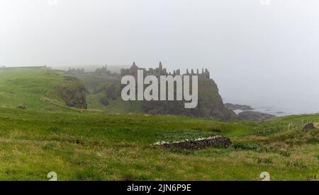Portrush, United Kingdom - 9 July, 2022: view of Dunluce Castle in thick fog on the Causeway Coastal Route Stock Photo