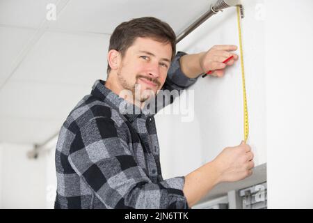 man is measuring vertical blinds Stock Photo