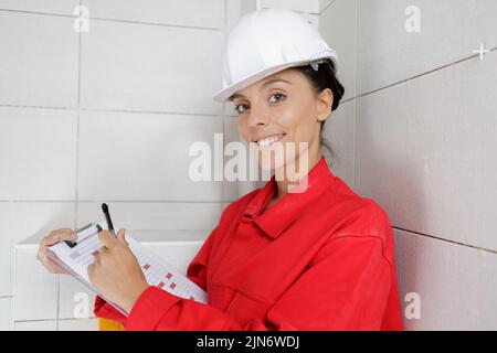 female builder writting on a clipboard Stock Photo