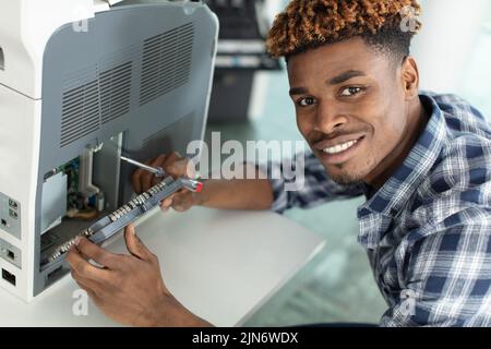 trying to repair the office printer at business place Stock Photo