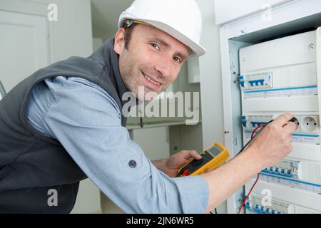 electrician testing circuit breaker with multimeter Stock Photo