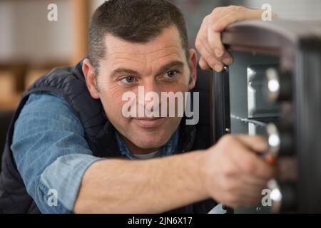man repairing an electrical oven Stock Photo