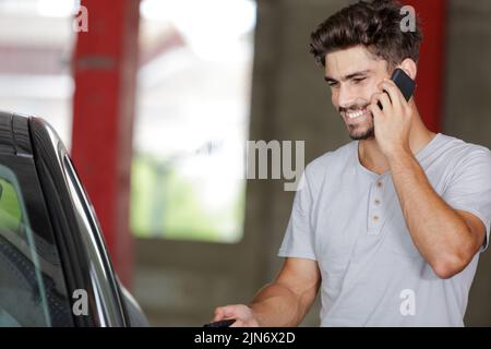 happy man on the phone opening car door Stock Photo