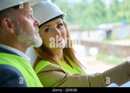 Close-up photo of faces of smiling female realtor and foreman Stock Photo