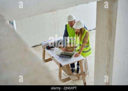 Beautiful woman manager and foreman looking at open laptop Stock Photo