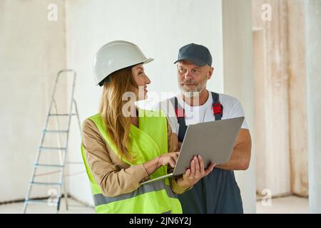 Agent communicates with adult worker hold open laptop in hands Stock Photo