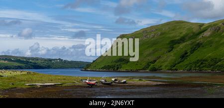 View of colorful stranded fishing boats at low tide in Loch Harport on the picturesque west coast of the Isle of Skye Stock Photo