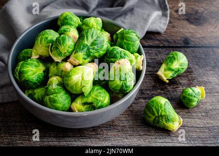 Fresh Brussels Sprouts in a Grey Ceramic Bowl: Overhead view of Brussels sprouts piled in a porcelain bowl Stock Photo