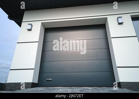 Automatic electric roll-up commercial garage gate or push-up door in modern private building ground floor Stock Photo