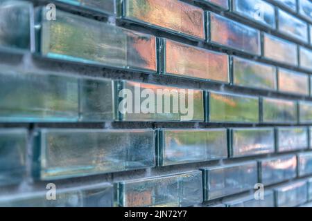 Close-up of a glass brick walls with reflective texture at Austin, Texas. Running bond pattern of a glass bricks with glossy exterior. Stock Photo