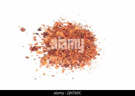 Crushed Red Hot Cayenne peppers. Pile crushed red cayenne pepper, dried chili flakes and seeds isolated on bright background. Close up view. Stock Photo