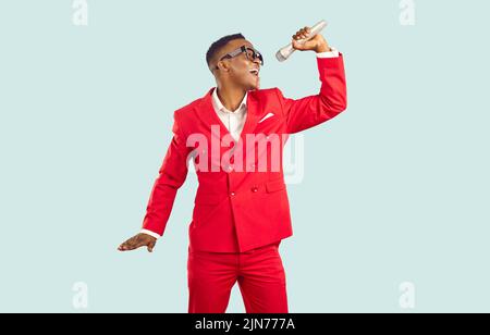 Young African American artist singing in microphone isolated on light background Stock Photo